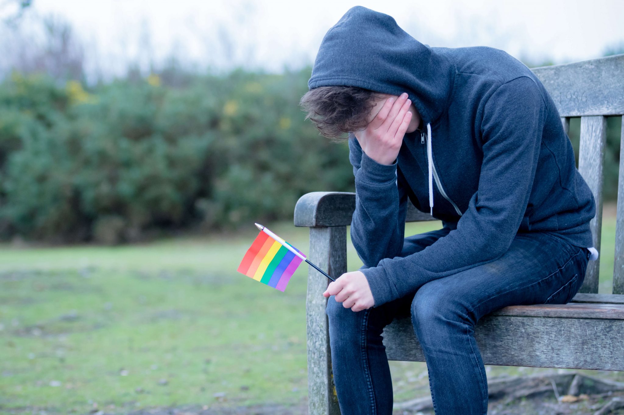 TWC as sad boy with LGBTQ flag copy - Teen World Confidential