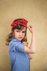 young girl flexing arm