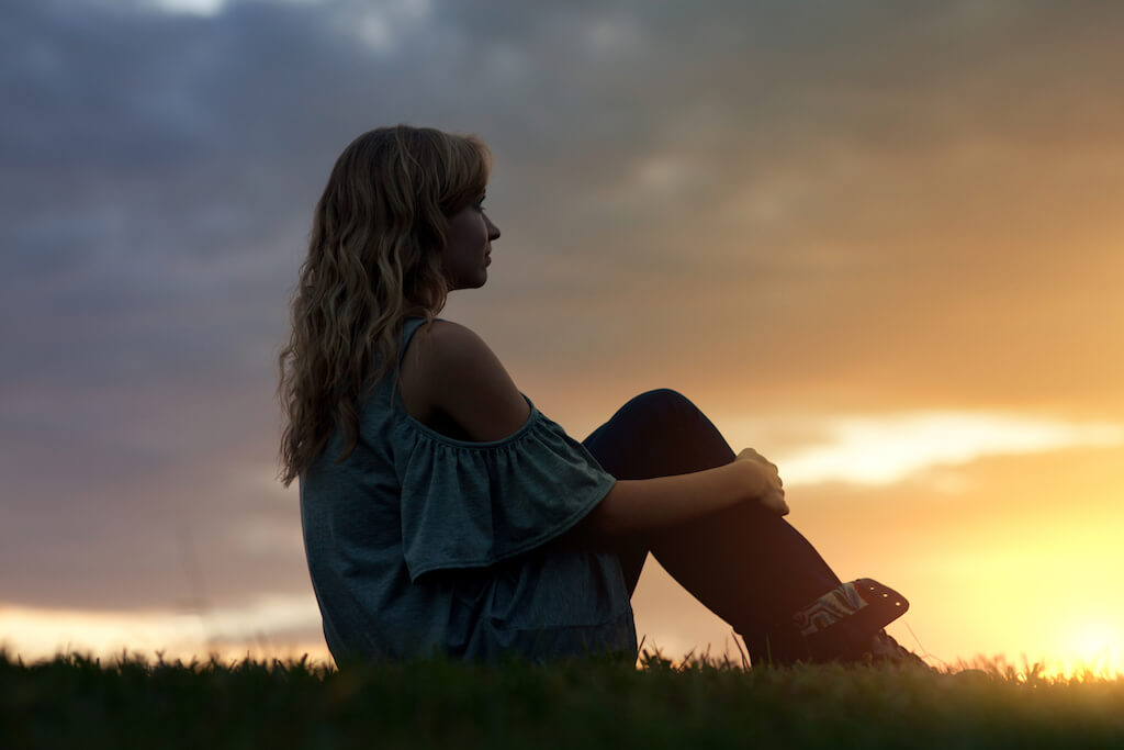 Teen Girl sitting at sunset - Teen World Confidential