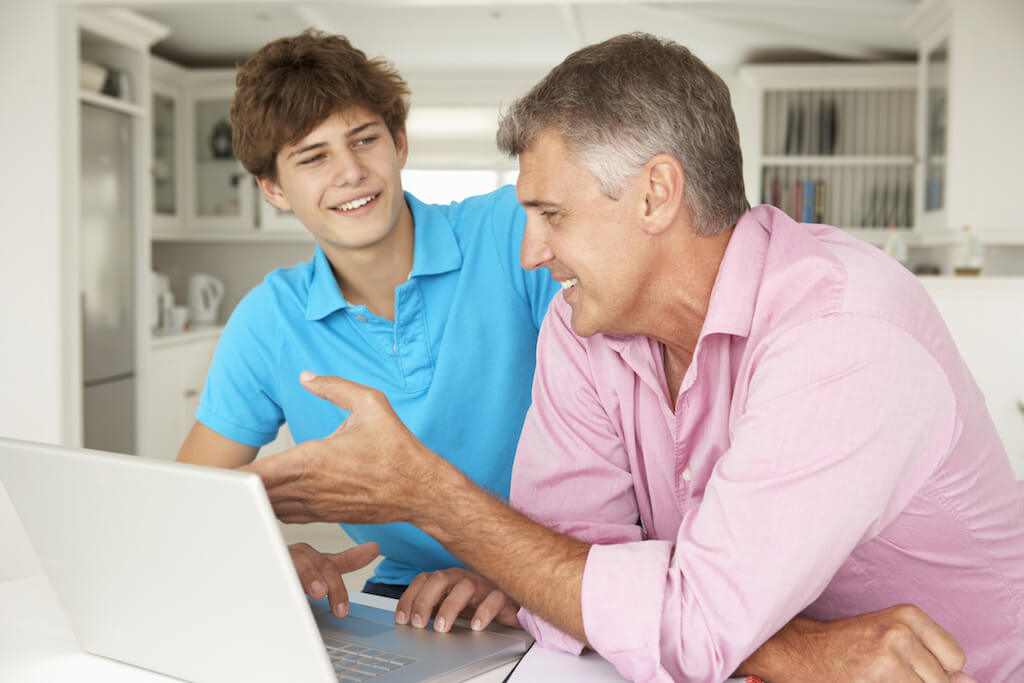 Dad and teen son at computer by Monkey Business - Teen World Confidential